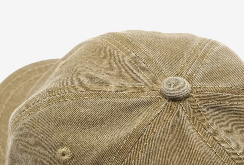 Close-up of the top panel and stitching on a washed brown logo-free baseball cap, highlighting the vintage cotton texture and classic six-panel construction.