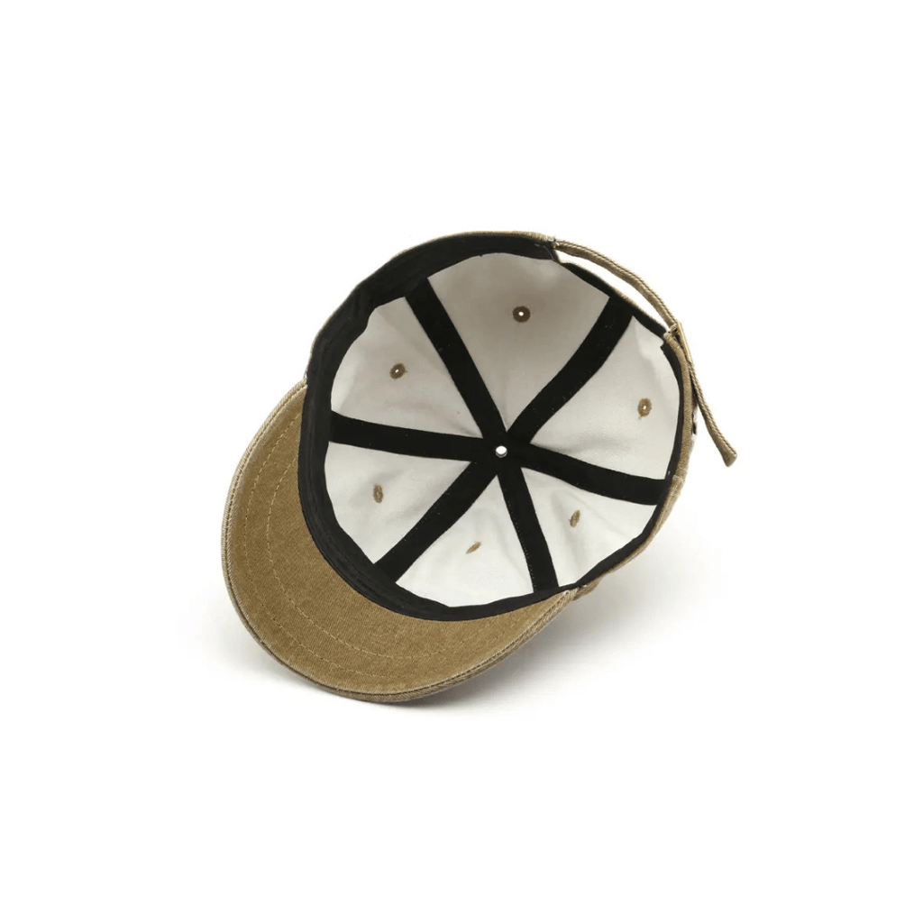 Interior view of a washed brown logo-free baseball cap, showing white inner lining, black seam taping, and reinforced six-panel construction with ventilation eyelets.